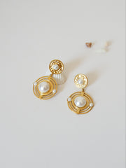 Boucles d'oreilles avec cercles et perle blanche au centre