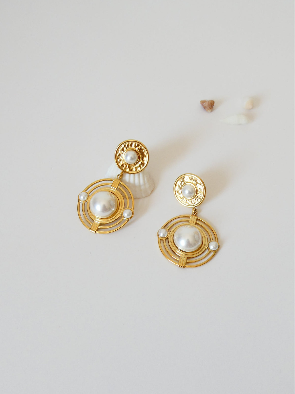 Boucles d'oreilles avec cercles et perle blanche au centre